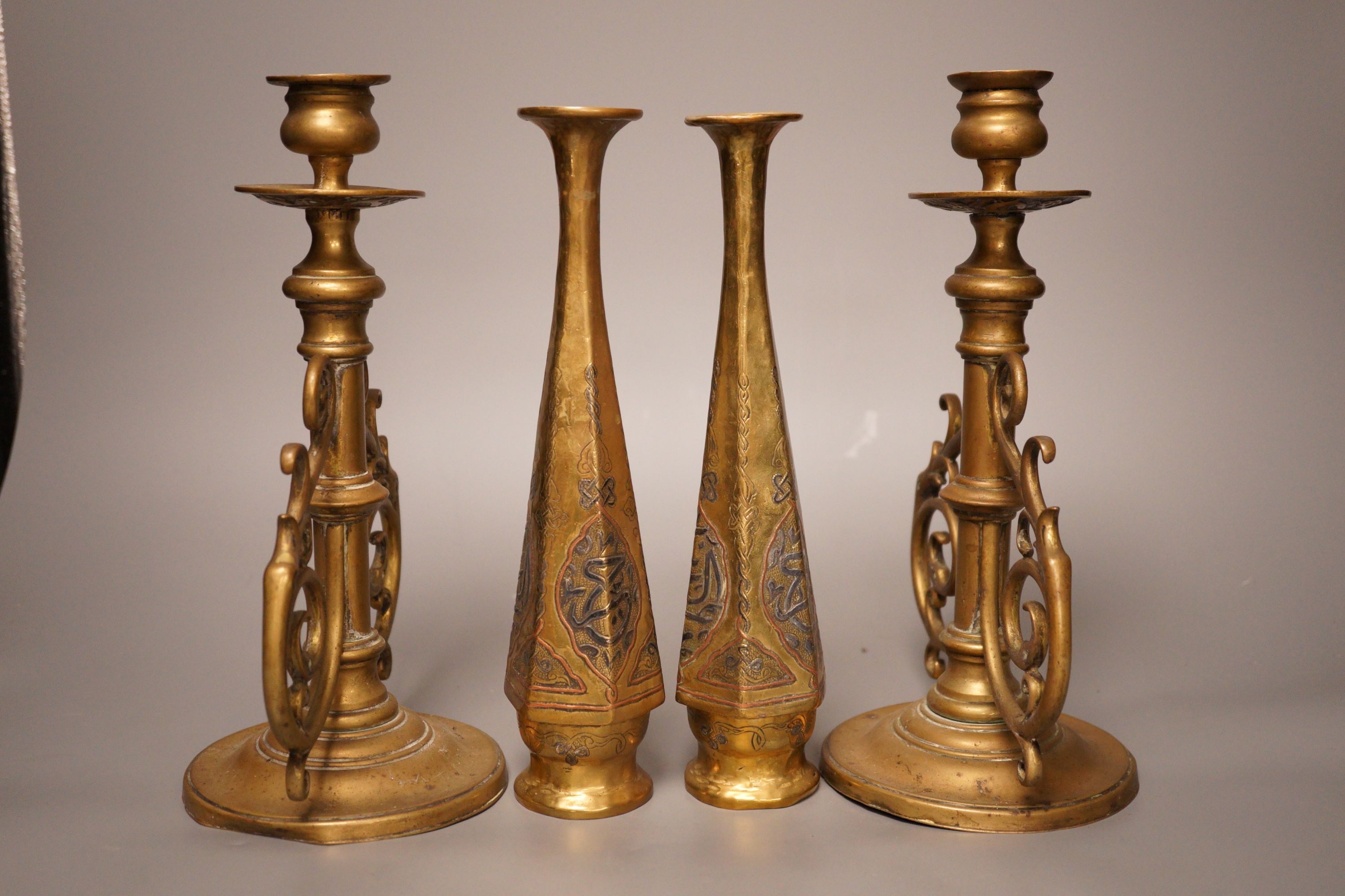 A pair of Victorian brass candlesticks and a pair of Arabic brass posy vases, tallest 25cm